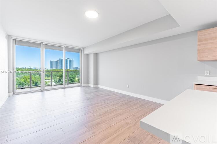 A spacious room with a large window overlooking a cityscape.