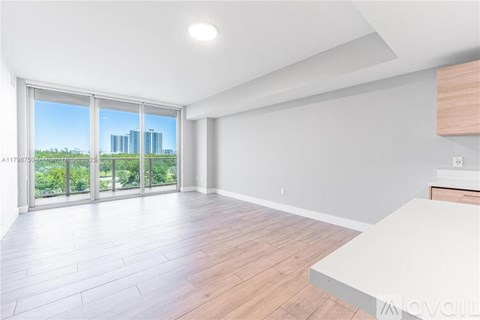 A spacious room with a large window overlooking a cityscape.