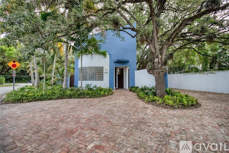 A blue house with a tree in front of it.