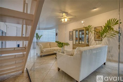 A living room with a white couch and a ceiling fan.