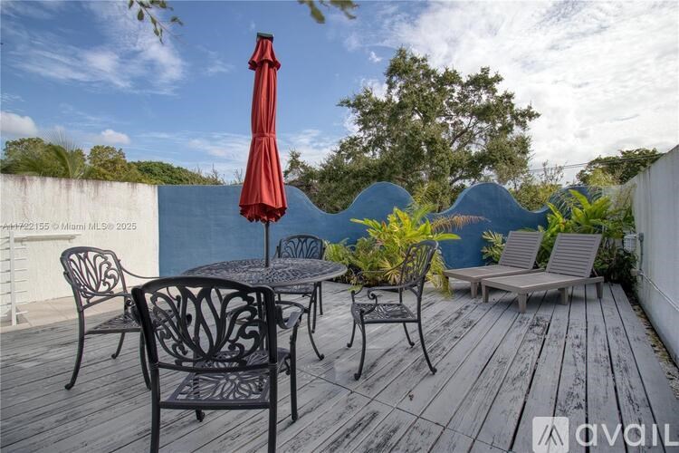 A patio with a table, chairs, and an umbrella.