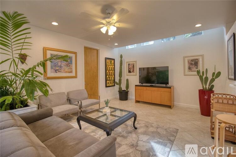 A living room with a glass coffee table and a flat screen TV.