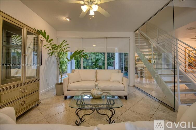 A living room with a glass coffee table and a white sofa.
