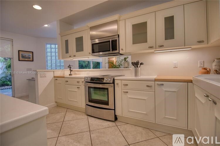 A kitchen with white cabinets and a tiled floor.