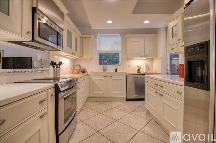 A kitchen with white cabinets and appliances.