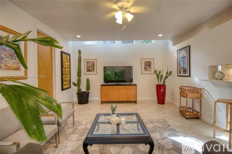 A living room with a grey sofa and a glass coffee table.