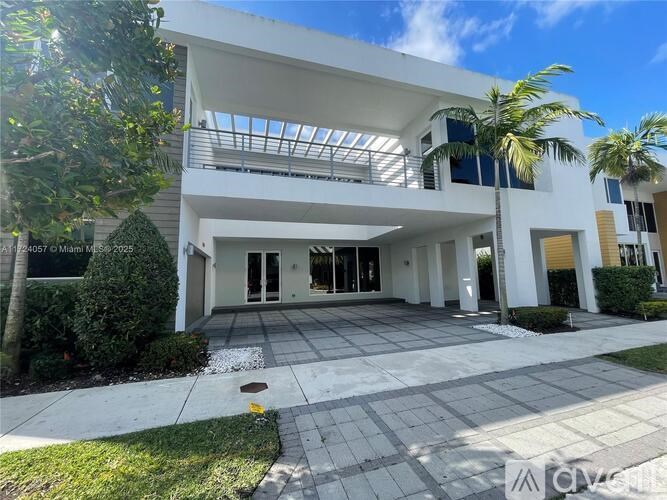 A modern house with a white exterior and a large covered patio area.