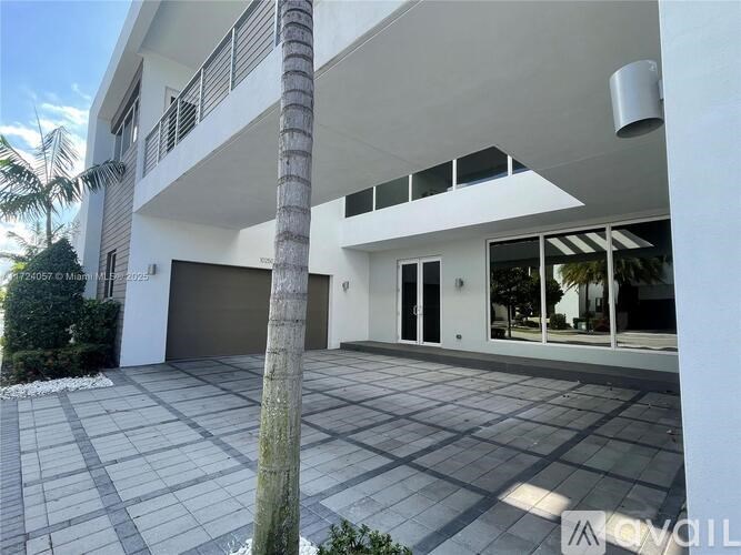 A modern house with a palm tree in front.