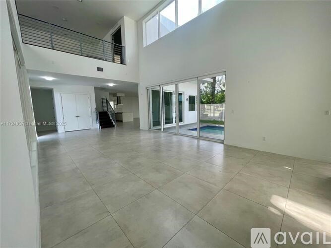 A spacious, empty room with tiled flooring and large windows.