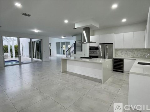 A modern kitchen with a central island and stainless steel appliances.