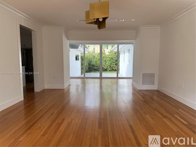A room with wooden flooring and a large window.