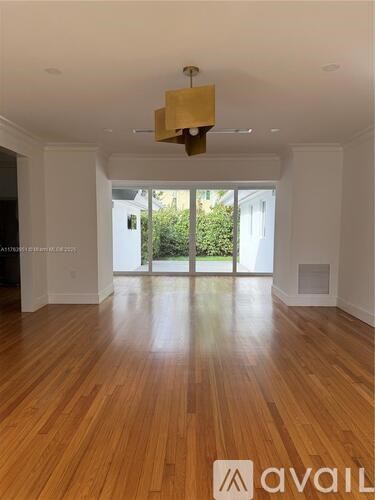 A room with wooden floors and a large window.