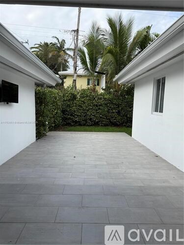 A patio area with a grey floor and white walls.