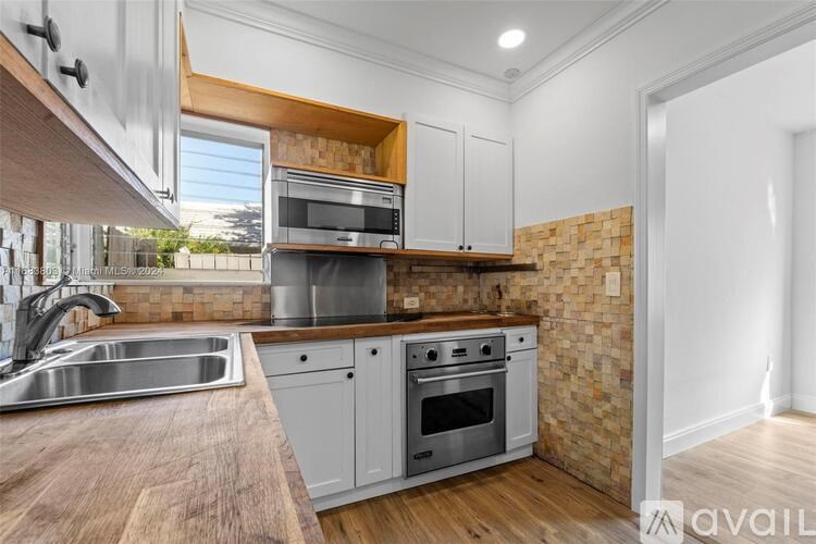 A kitchen with a brick wall and wooden cabinets.