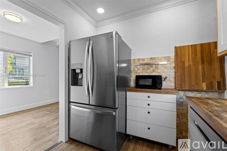 A modern kitchen with a stainless steel refrigerator and wooden countertops.
