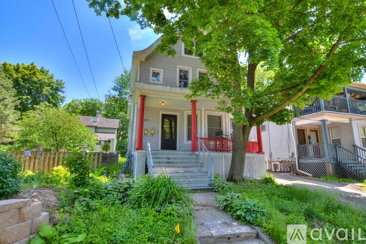 A house with a red door and a tree in front.