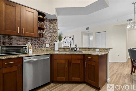 A kitchen with wooden cabinets and a stainless steel dishwasher.