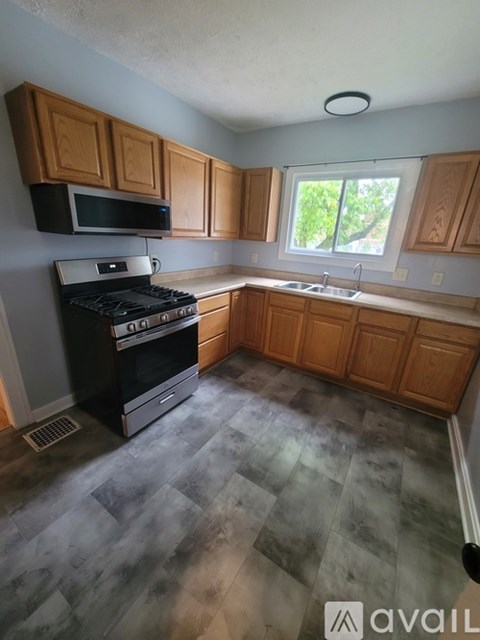 A kitchen with wooden cabinets and a black stove top oven.