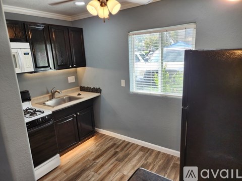 A kitchen with black cabinets and a white oven.