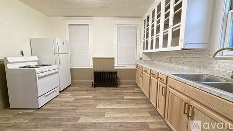 A kitchen with wooden floors and white appliances.