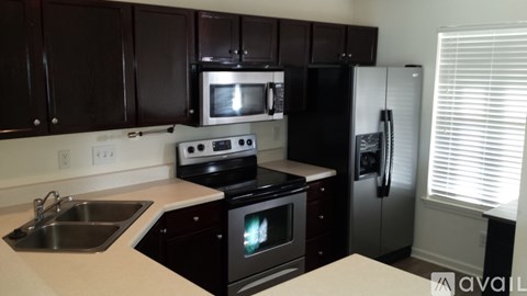 A kitchen with black cabinets and a white countertop.