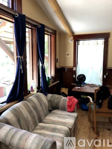 A living room with a striped couch and a table with a fan.