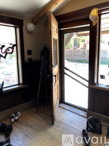 A room with a wooden floor and a large open door.