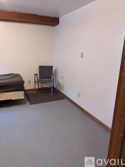 A room with a bed, chair and mattress.