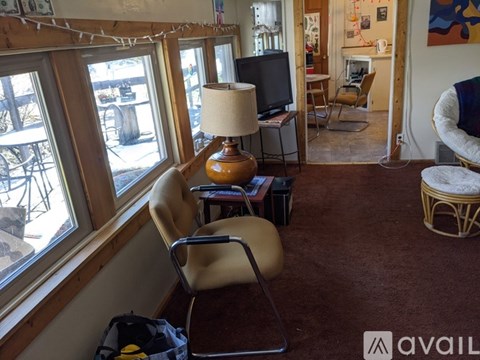 A living room with a brown carpet and a chair.