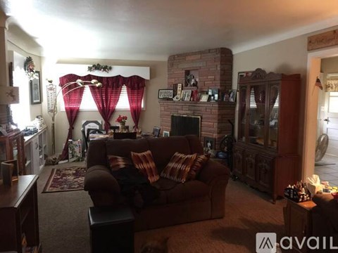 A living room with a brown couch and a fireplace.