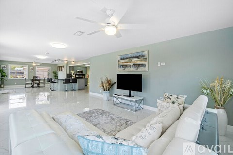A living room with a white couch and a television.