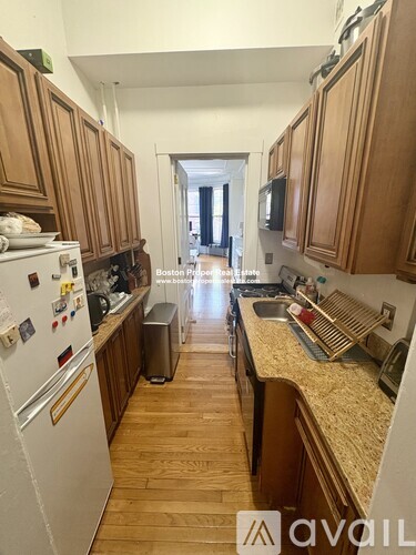 A kitchen with wooden cabinets and a white fridge.