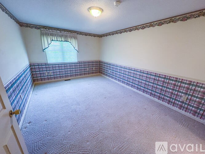 A room with a checkered floor and a window with blinds.