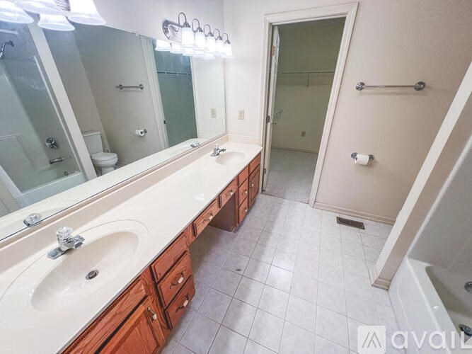 A bathroom with a sink, mirror, and a shower.