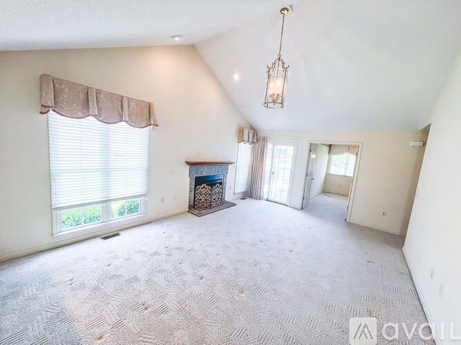 A living room with a fireplace and a carpeted floor.