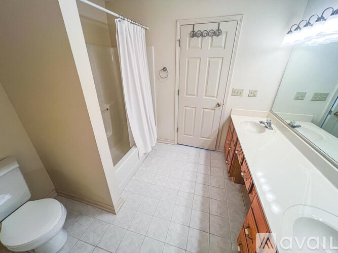 A white bathroom with a toilet, sink, and shower.