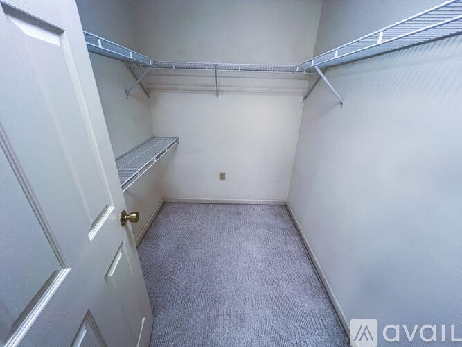 A small, empty room with a carpeted floor and a white door.