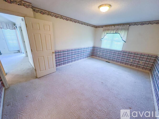 A room with a checkered floor and a window with blinds.