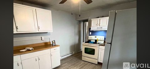 A kitchen with white cabinets and a wooden countertop.