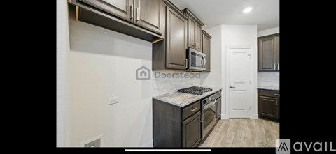 A kitchen with dark wood cabinets and a white door.