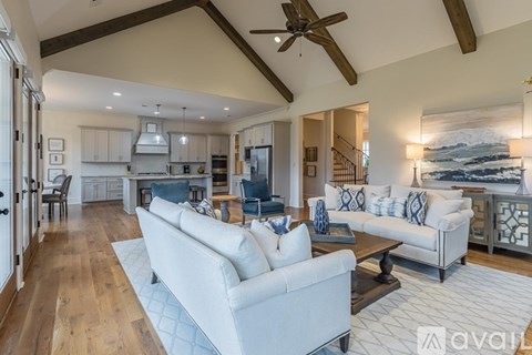 A living room with a white couch and a ceiling fan.