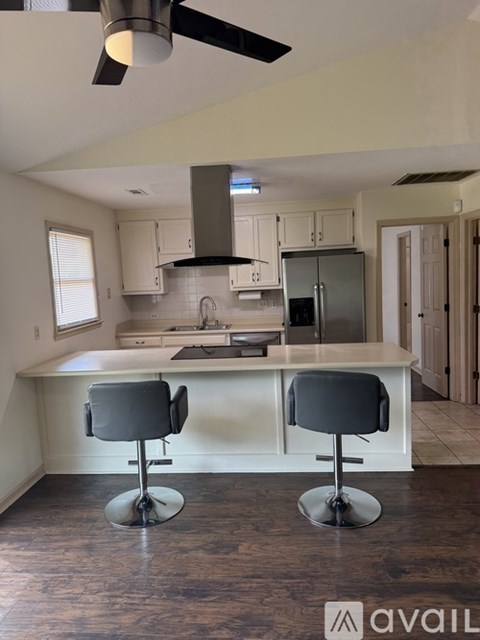A kitchen with a bar stool in front of it.