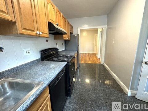 A kitchen with wooden cabinets and black appliances.