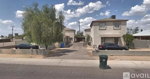 A street view with a house, cars, and a tree.