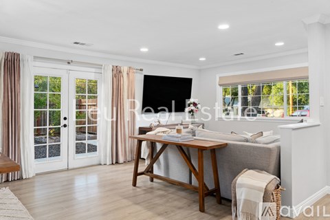 A well-lit living room with a dining table and a sofa.