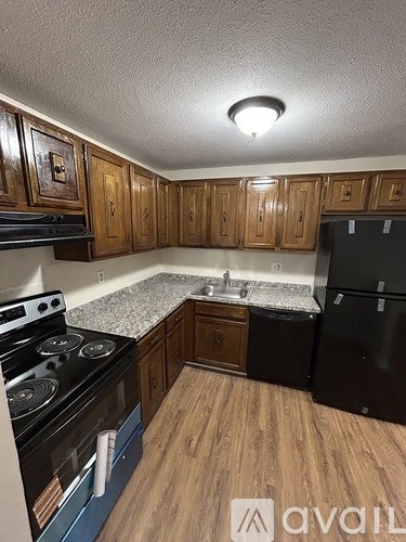 A kitchen with wooden cabinets and a black stove top oven.