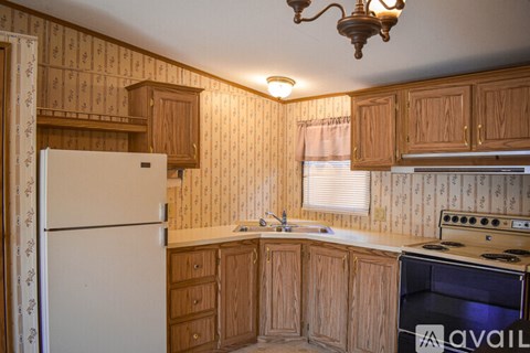 A kitchen with wooden cabinets and a white refrigerator.