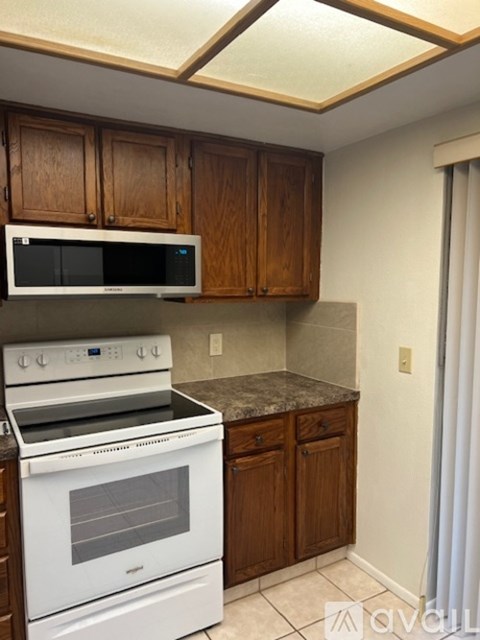 A kitchen with a white oven and microwave above it.