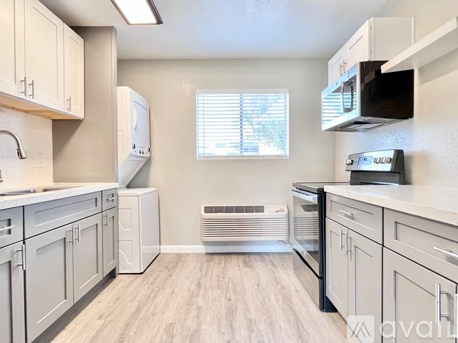 A kitchen with white cabinets and appliances.