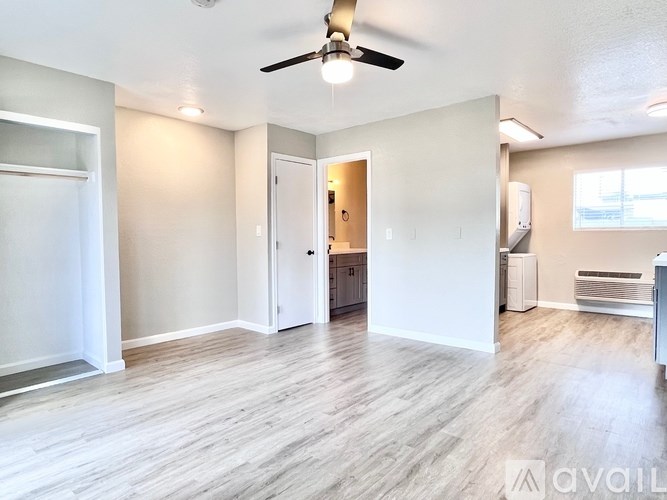 A spacious room with a ceiling fan and lighting fixtures.
